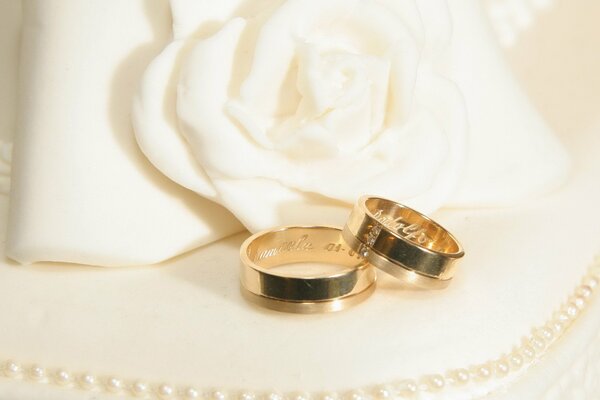 Wedding rings on a background of jewelry and white flowers