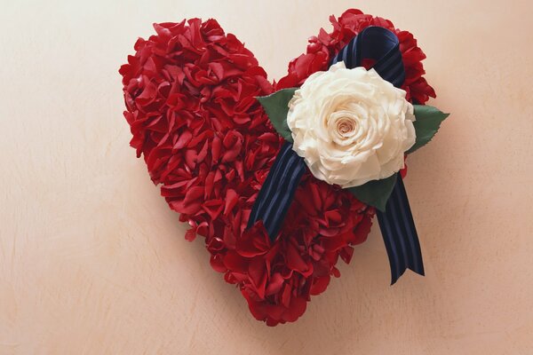 A red heart of petals decorated with a rose flower