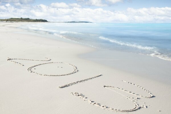 Inschrift des Jahres 2013 auf dem Sand am Strand in der Nähe des Meeres