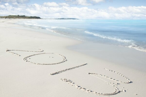 Надпись 2013 года на песке на пляже около моря
