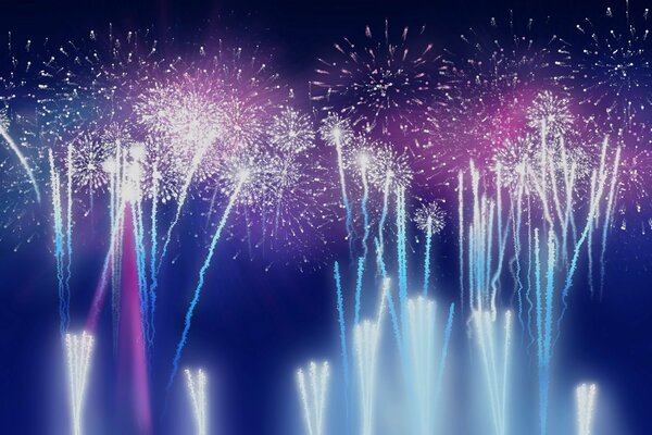Multicolored fireworks on a blue sky background