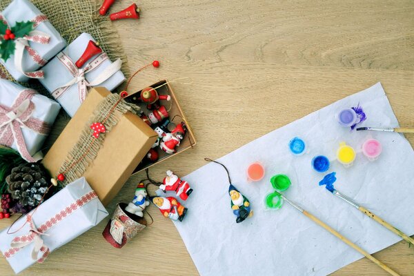 Una hoja de papel con pinturas y regalos en el piso