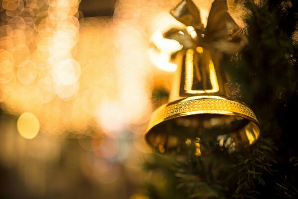 Große goldene Glocke, die am Weihnachtsbaum hängt