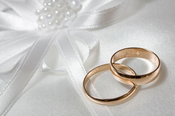 Dos anillos de boda en tela blanca