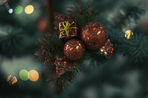 Geschenk und Bälle, die am Weihnachtsbaum hängen