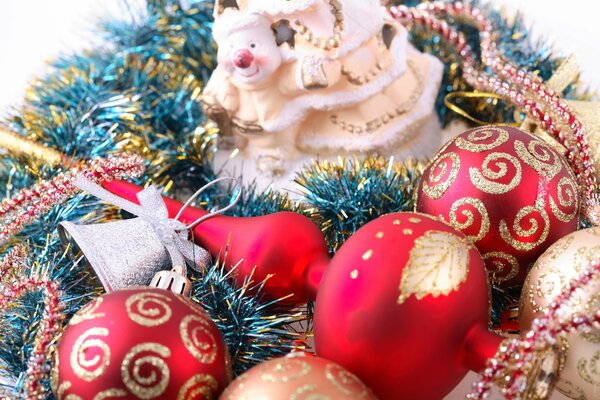 Rote Weihnachtskugeln und eine Spitze am Weihnachtsbaum unter Lametta