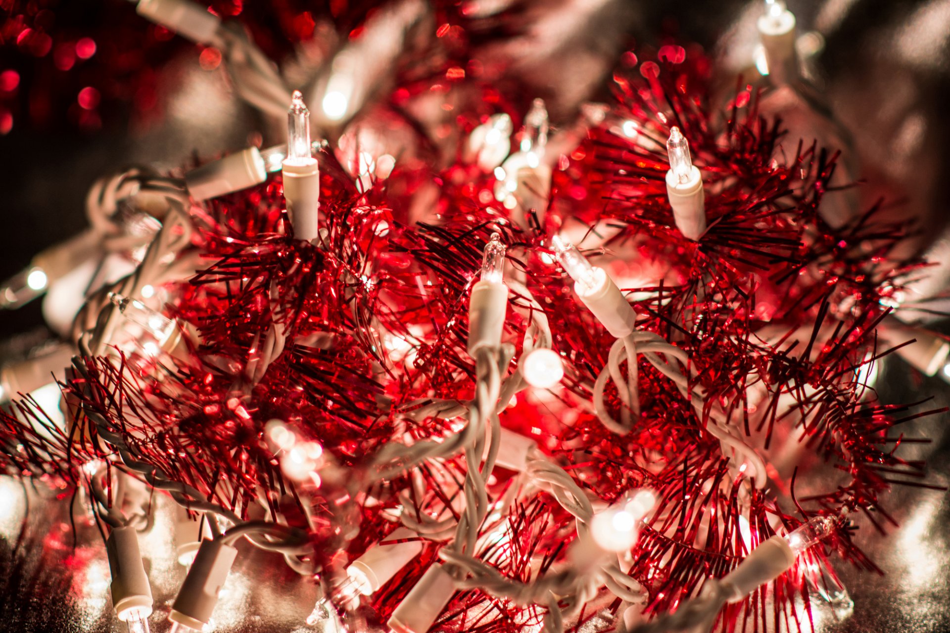 garland lights light tinsel rain red bokeh close up holidays winter