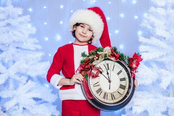 Il ragazzo in berretto sanyta tiene l orologio