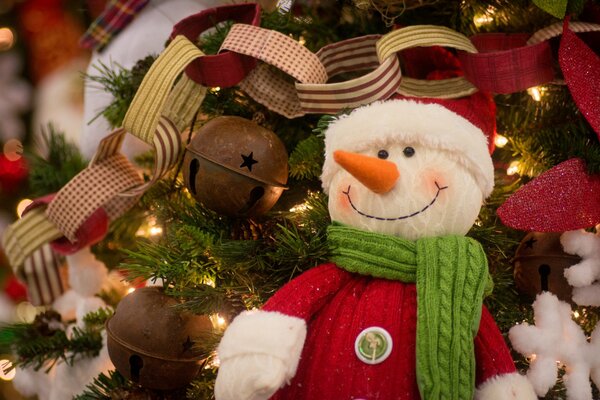 A snowman on the Christmas tree along with other decorations