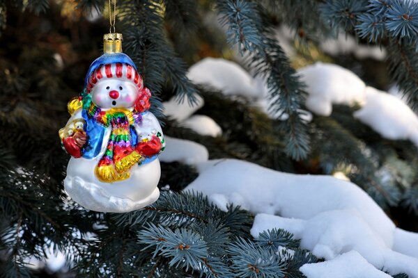 Muñeco de nieve de juguete en el árbol de Navidad