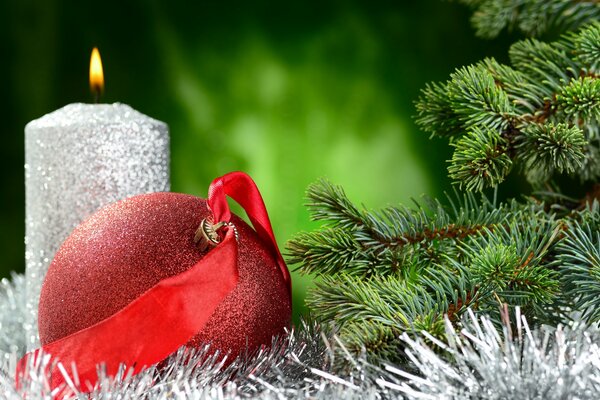 Vela de plata con bola roja en el árbol de Navidad