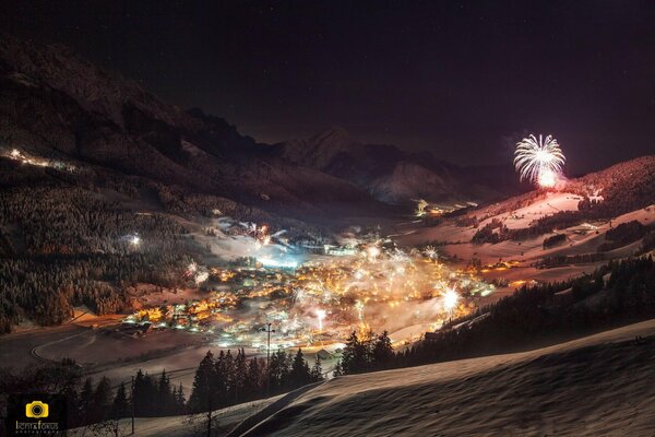 Winternachtstadt mit Lichtern und Feuerwerk