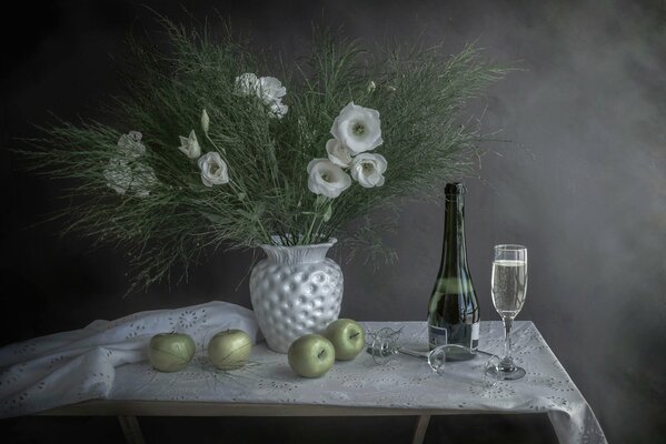 Nature morte du nouvel an avec des fleurs, des pommes et du champagne