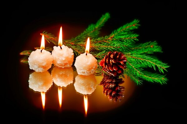 New Year candles with a Christmas tree twig and a cone