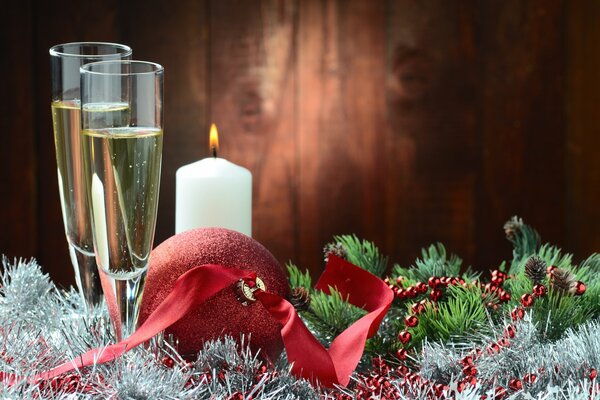 Two glasses of champagne with tinsel and a Christmas tree