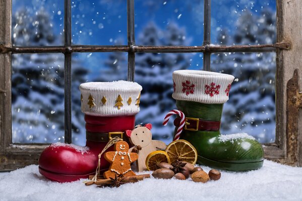 Scarpe di Babbo Natale e decorazioni di Natale sullo sfondo della finestra