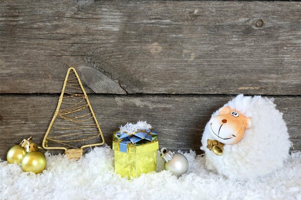 Chèvre duveteuse dans la neige avec des cadeaux et des chevrons