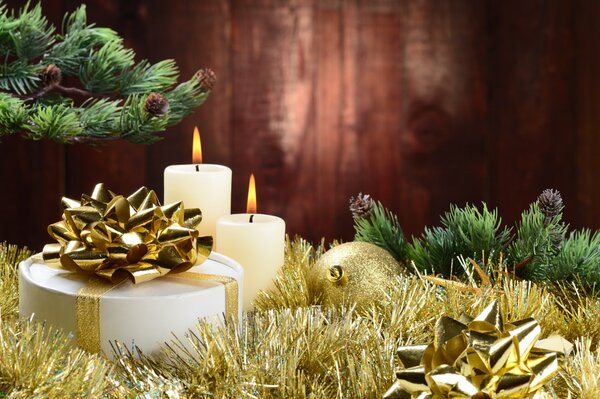 Burning candles and a gift decorated with a gold ribbon