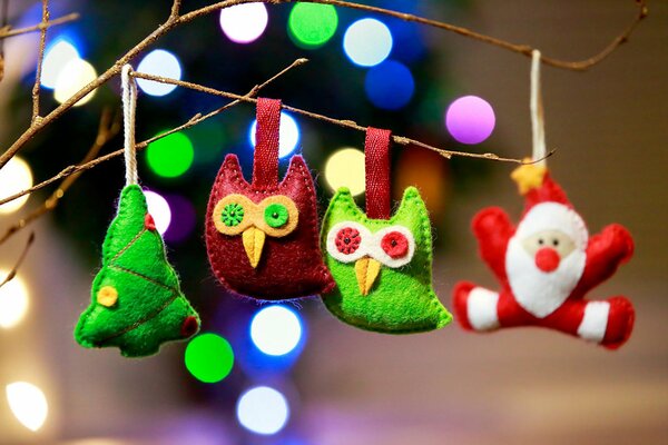 Green and red owls with a Christmas tree and Santa Claus on a branch