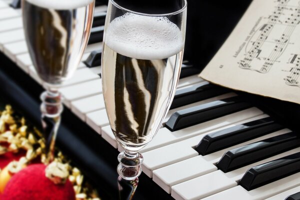 Verres à vin avec du champagne sur fond de piano à queue