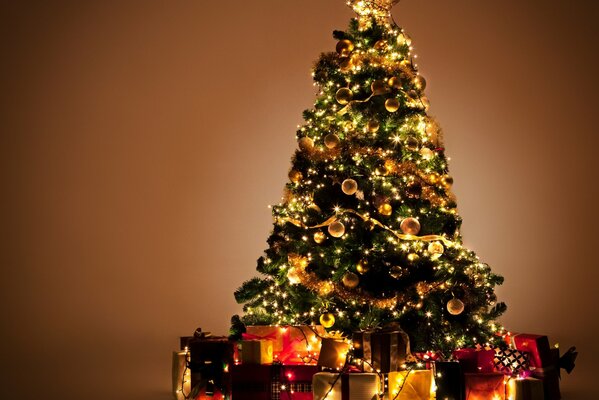 Jouets lumineux suspendus sur l arbre de Noël. Les cadeaux attendent les gars