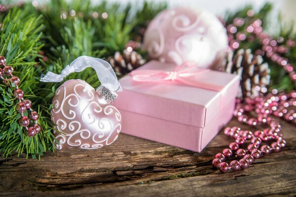 Fir branch with pink beads, gift and Christmas balls