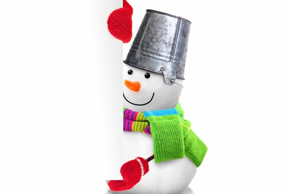 A snowman with a green scarf and a bucket on his head