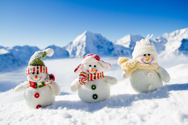 Tres muñecos de nieve en bufandas y sombreros