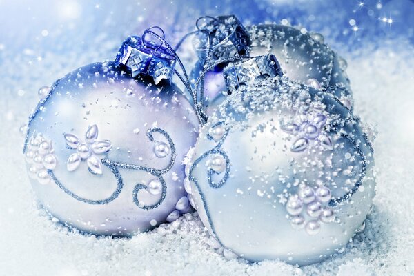 Boules blanches dans la neige pour le nouvel an