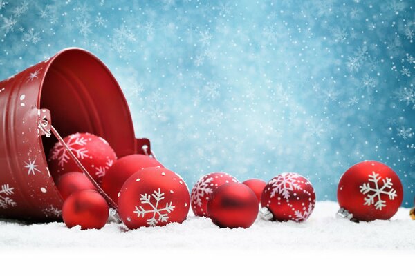 Red Christmas balls on a blue background with snowflakes