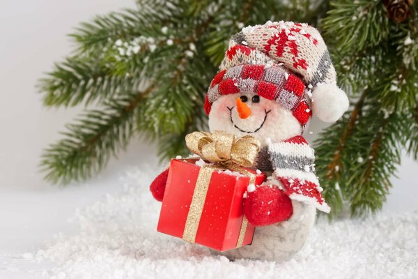 Muñeco de nieve sostiene una Caja de regalo roja