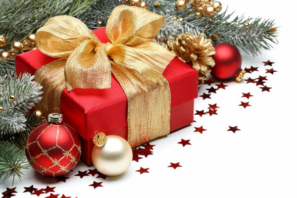 Geschenk mit goldenem Band und Weihnachtskugeln