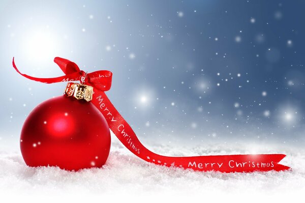 A red ball with a red ribbon on a background of snowflakes