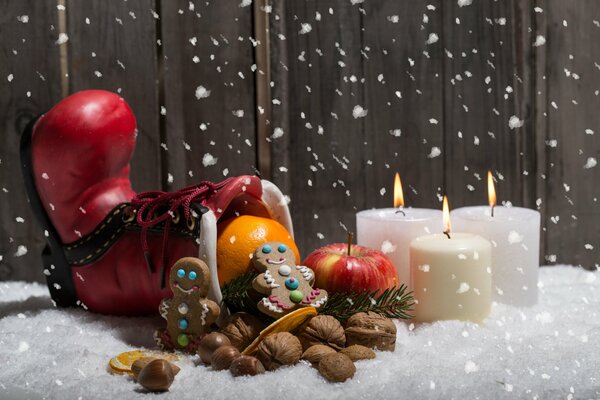 Leckereien und Kerzen liegen im Schnee