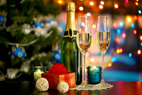 Champagne and two glasses on the background of a Christmas tree