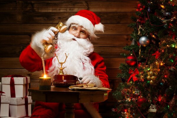 Święty Mikołaj siedzi przy telefonie