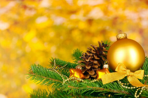 Świerkowa łapa z dekoracjami noworocznymi na żółtym tle