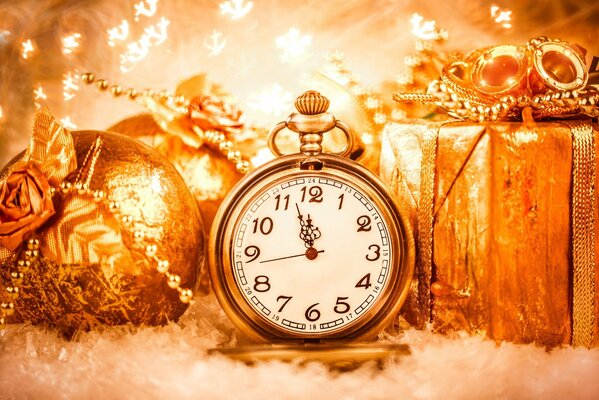 Joyas de oro de cobre hechas de bolas de rosas y regalo y en el reloj tres minutos antes del año nuevo