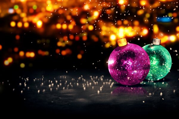 Two Christmas balls on a bright background of lights