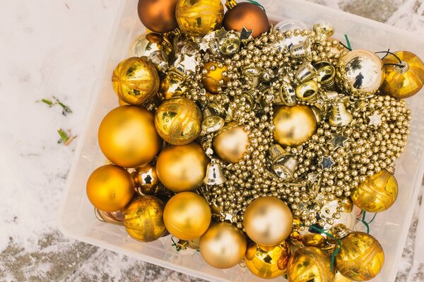 Boîte avec des boules d or de Noël et des perles