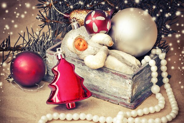 Sous l arbre de Noël se trouvent Snow Maiden dans une boîte, des boules, un jouet de Noël et des perles blanches