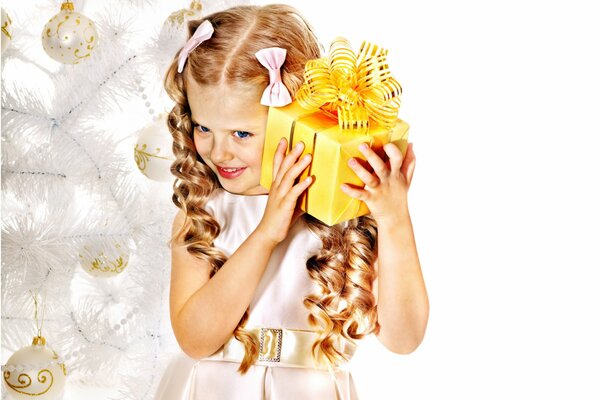 Девочка с локонами и бантиками с новогодним подарком