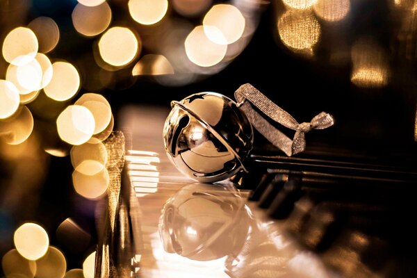 A golden Christmas ball is lying on the keys