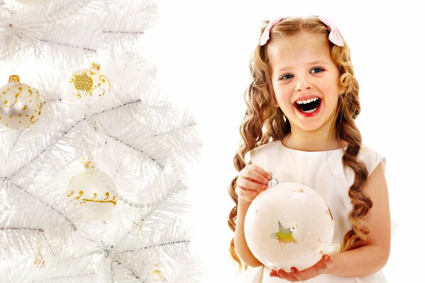 A girl with a Christmas tree toy diligently enjoys the holiday