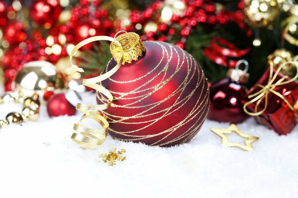 Red Christmas ball in the snow close-up