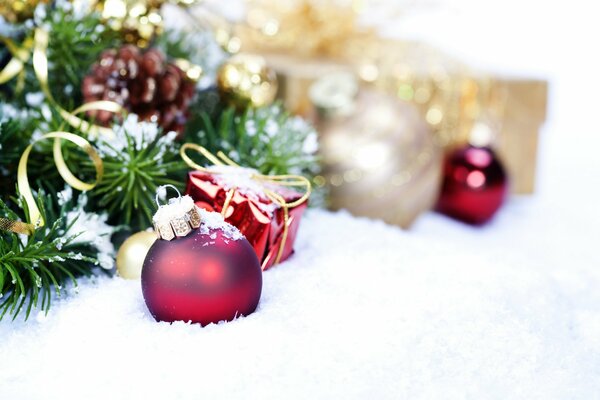 Weihnachtsspielzeuge liegen im Schnee neben dem Weihnachtsbaum