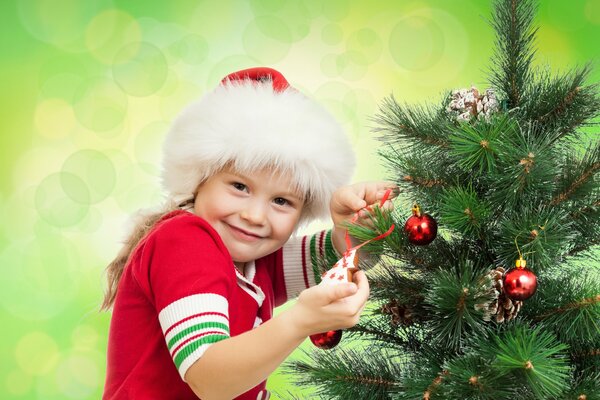 Niño de pie en el árbol de Navidad