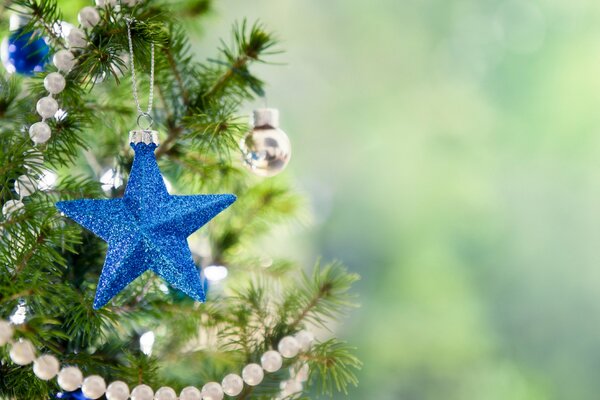 Blauer Christbaumschmuck in Form eines Sterns am Weihnachtsbaum