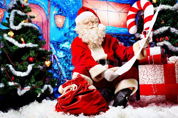 Santa Claus with gifts near the Christmas tree