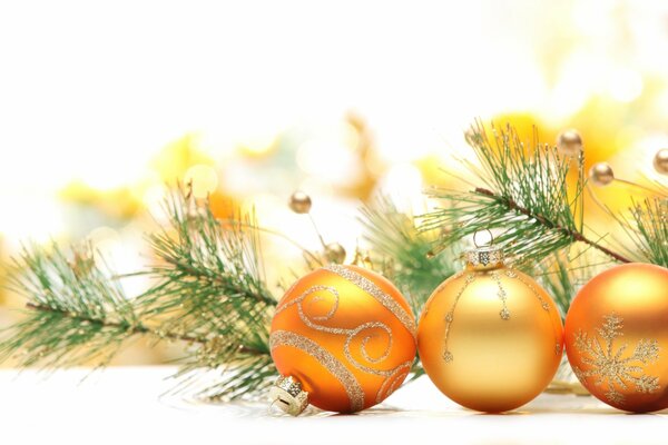 Trois boules de Noël dorées et une branche d épinette